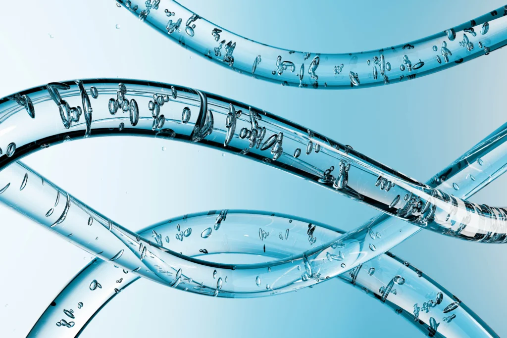 Close-up view of three transparent, twisting tubes filled with air bubbles against a gradient blue background.