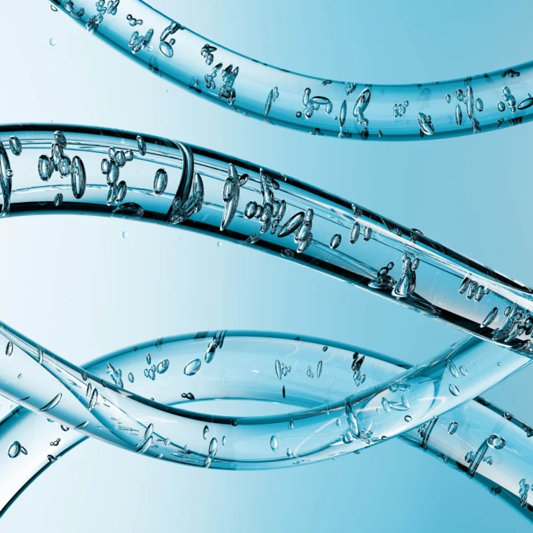 Close-up view of three transparent, twisting tubes filled with air bubbles against a gradient blue background.